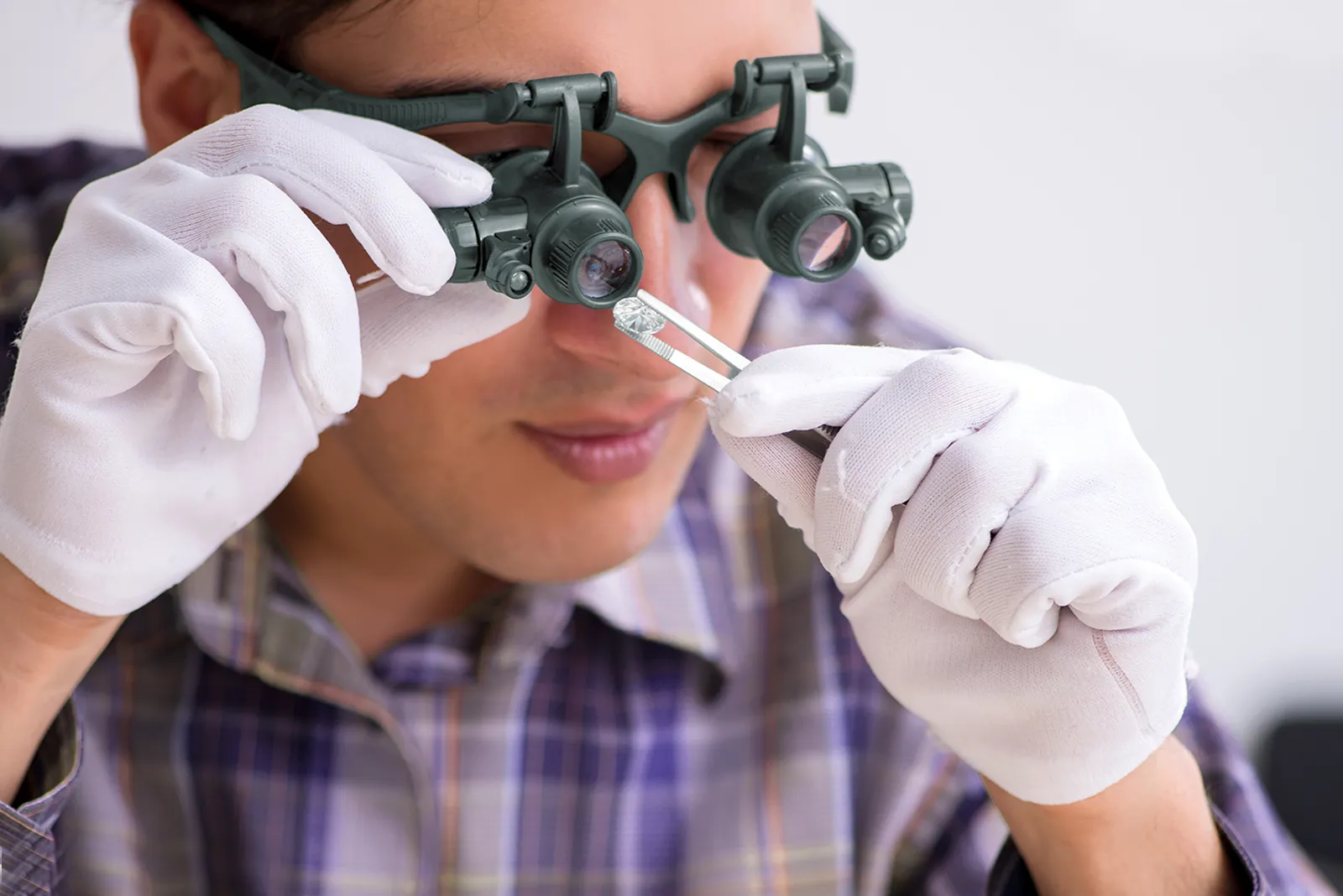 Expert wearing Binocular Magnifier to identify and grade diamonds. Authenticity of a diamond. Natural Round-Cut Diamonds: Revitalizing the Diamond Market: How Jewelers Can Spark Customers’ Interest in Natural Stones. US