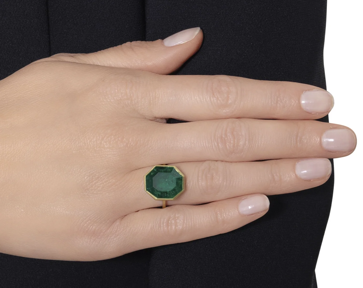 Bezel set octagonal-shaped step cut 10.97carat emerald ring on the finger. Sotheby’s Winter Auction Shines with Iconic Jewelry and Charitable Contributions. US