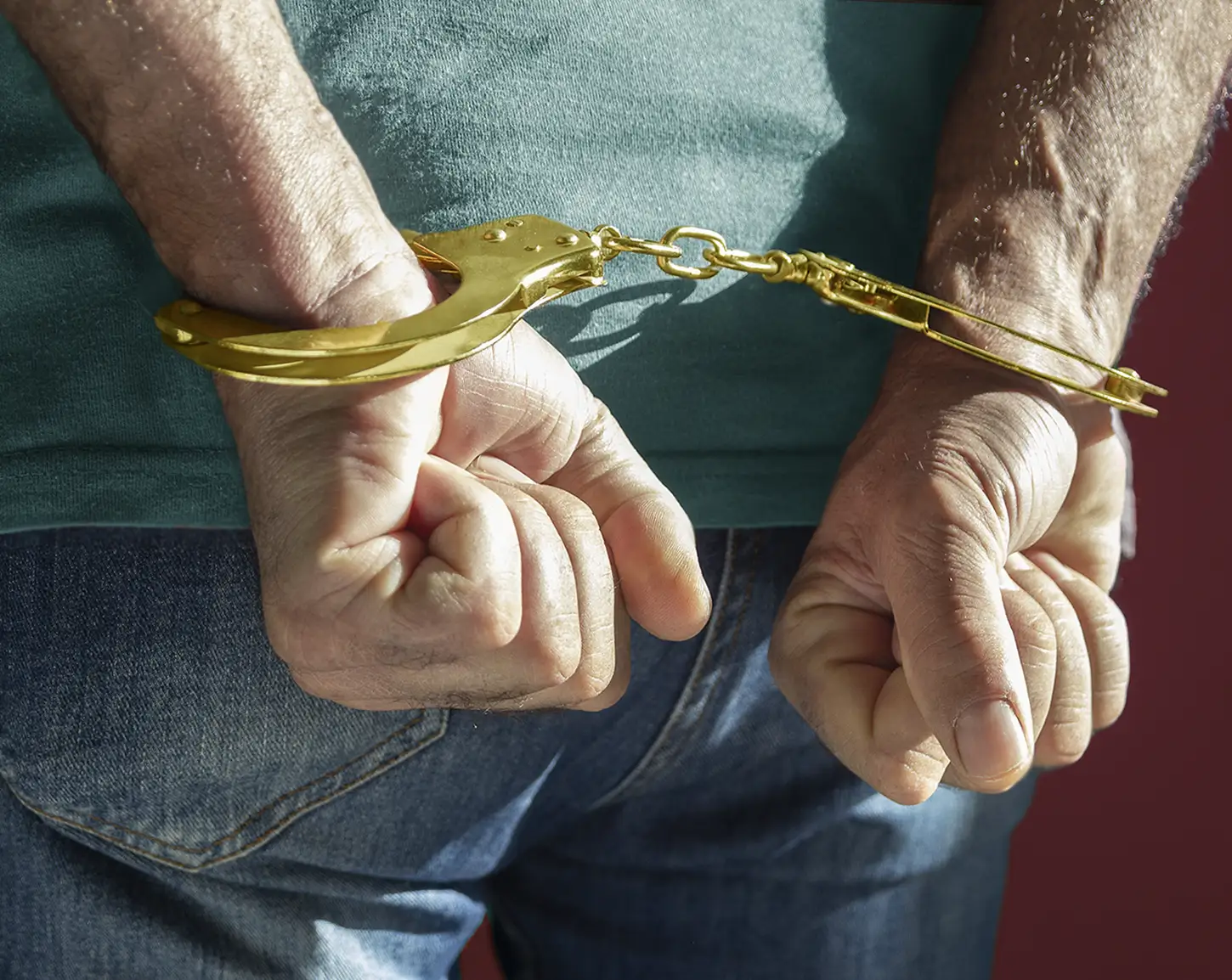 Arrested male jeweler in handcuffs. Killer arrested for killing his boss. Former NYC Jewelry Worker Is Charged with Killing His Employer. News