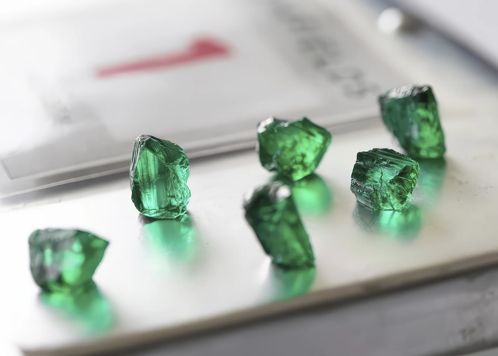 Rough emeralds lie on the table. Gemfields Will Open Its Second Ruby Plant, Which Will Increase Production in Mozambique. News