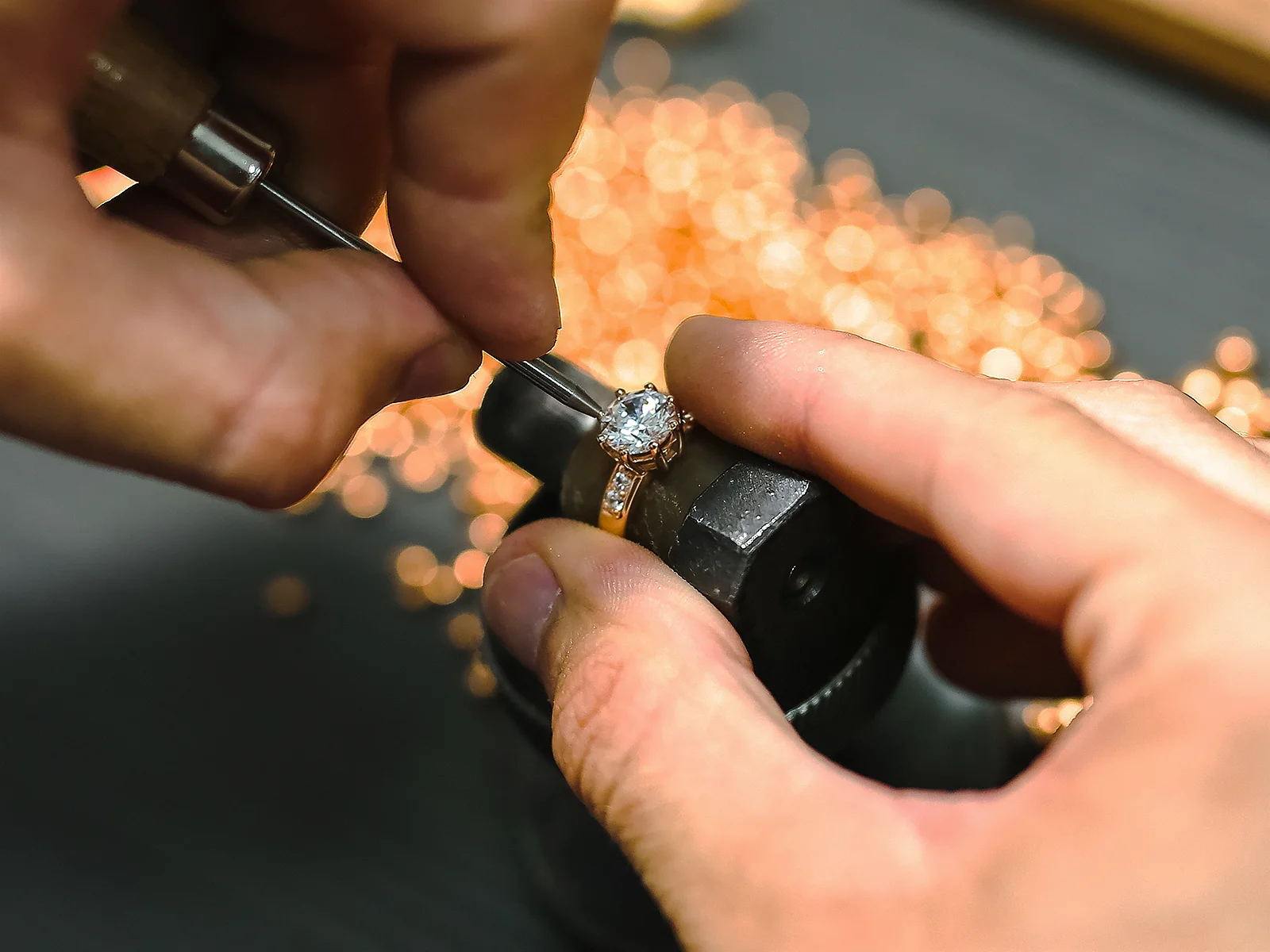 Jeweler resetting an heirloom diamond ring into a new custom setting during the heirloom diamond reset process. US